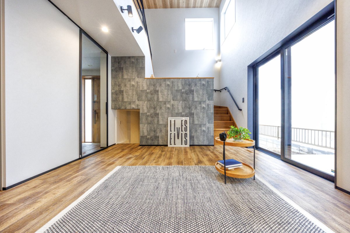 スキップフロアと吹き抜け。天井高の窓から入る日差しで明るいLDKに。