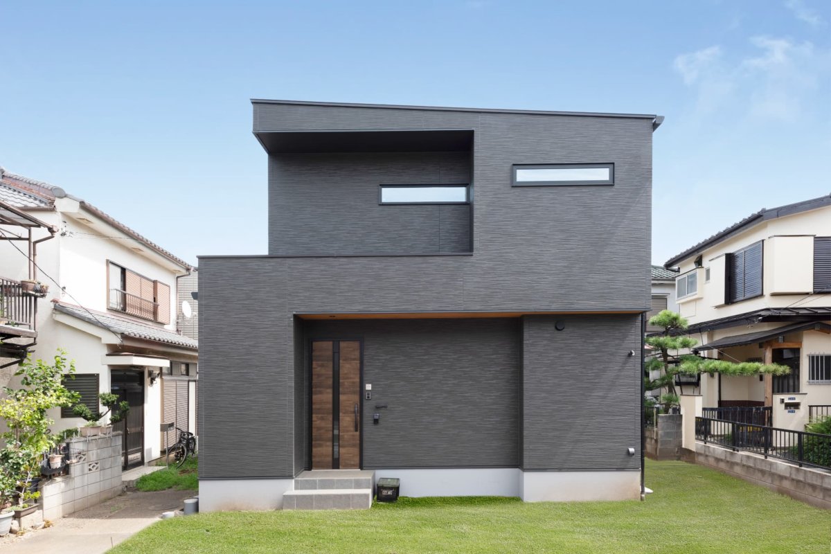 ブラックを基調としたボックス型のモダンな外観。木目の軒天がアクセントに。