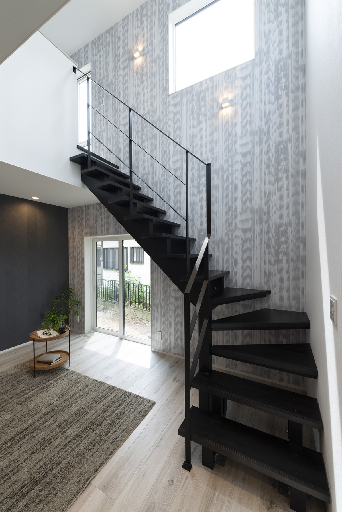 抜け感を生み出す鉄骨階段と天井高の窓